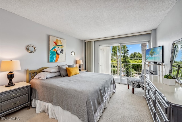 carpeted bedroom with a textured ceiling and access to exterior