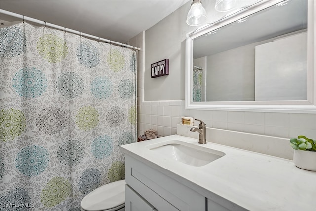 bathroom featuring tile walls, walk in shower, vanity, and toilet