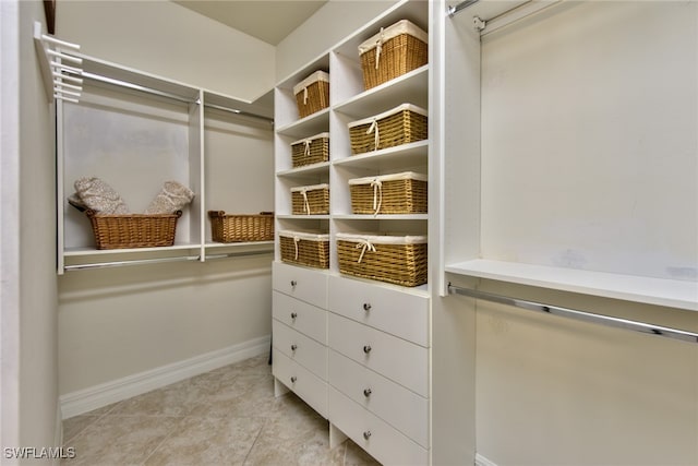 walk in closet with light tile patterned floors