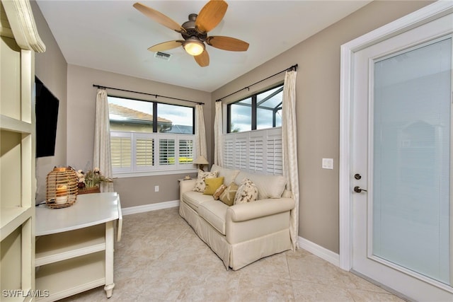 living area featuring ceiling fan and light tile patterned floors