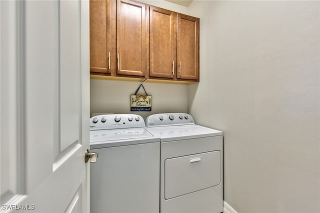 laundry room featuring cabinets and washer and clothes dryer