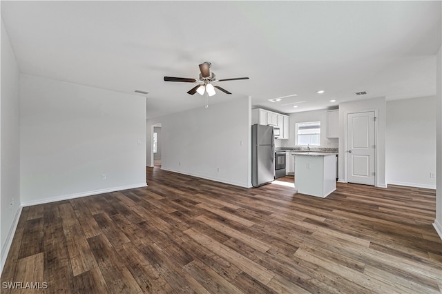 unfurnished living room featuring dark hardwood / wood-style floors and ceiling fan