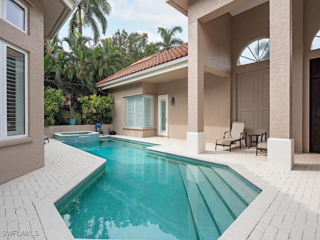 view of pool with an in ground hot tub and a patio