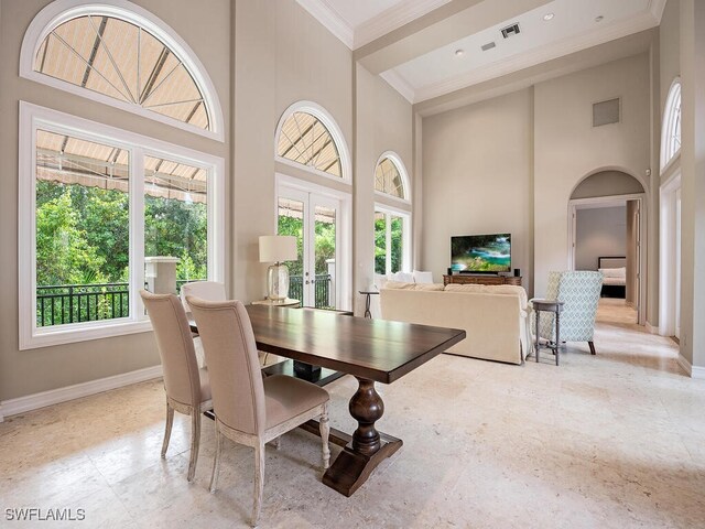 dining room featuring french doors, ornamental molding, and a high ceiling