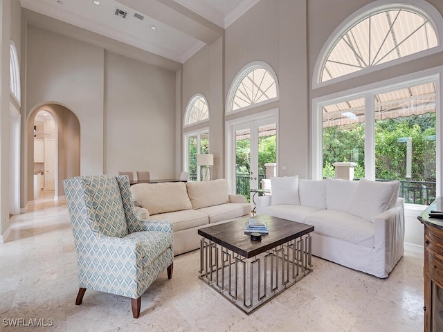 living room featuring a high ceiling and crown molding