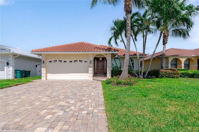 mediterranean / spanish house featuring a garage and a front lawn