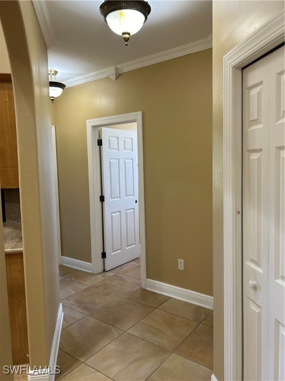 hallway with light tile patterned floors and crown molding