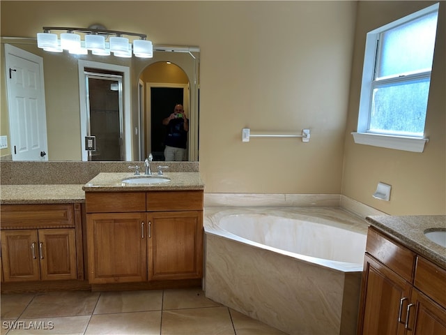 bathroom featuring tile patterned floors, vanity, and shower with separate bathtub