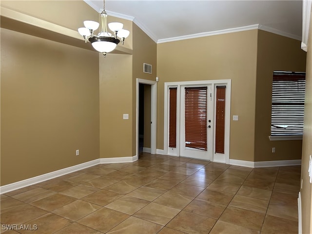 tiled entryway featuring a towering ceiling, ornamental molding, and a notable chandelier