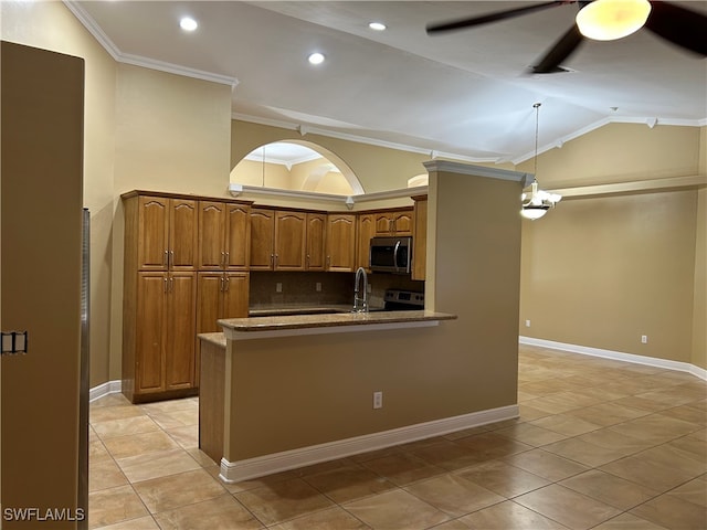 kitchen featuring appliances with stainless steel finishes, backsplash, vaulted ceiling, crown molding, and pendant lighting