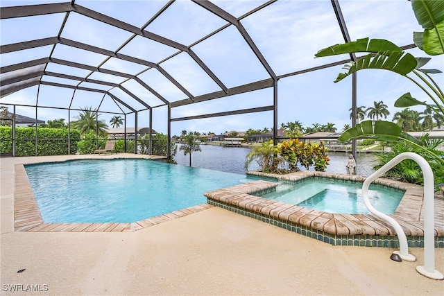 view of pool with glass enclosure, a patio area, a water view, and an in ground hot tub