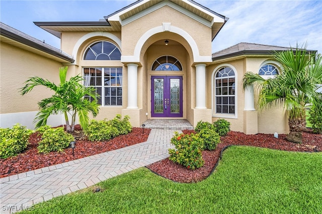 property entrance with a lawn and french doors