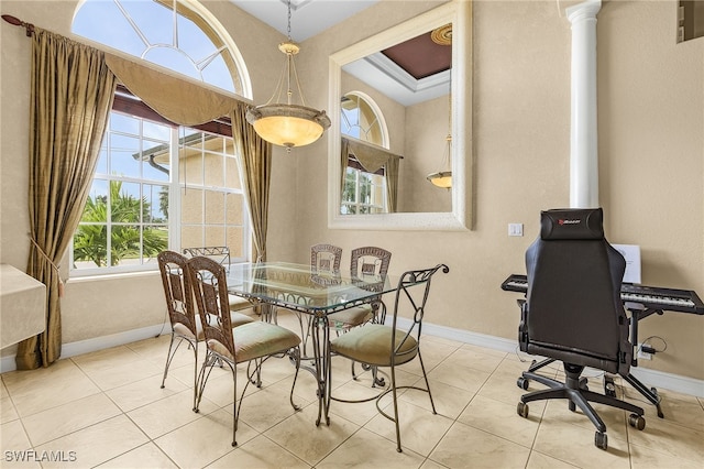 dining room featuring a healthy amount of sunlight, ornate columns, and light tile patterned floors