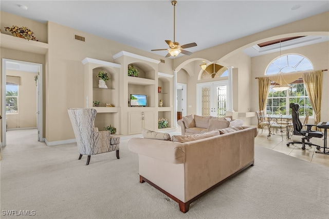 carpeted living room featuring ceiling fan, built in features, and french doors