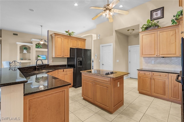 kitchen featuring black appliances, sink, light tile patterned floors, a kitchen island, and kitchen peninsula