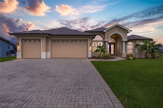 view of front facade with a lawn and a garage