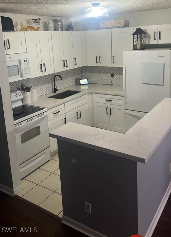 kitchen with sink, white cabinetry, white appliances, and tasteful backsplash