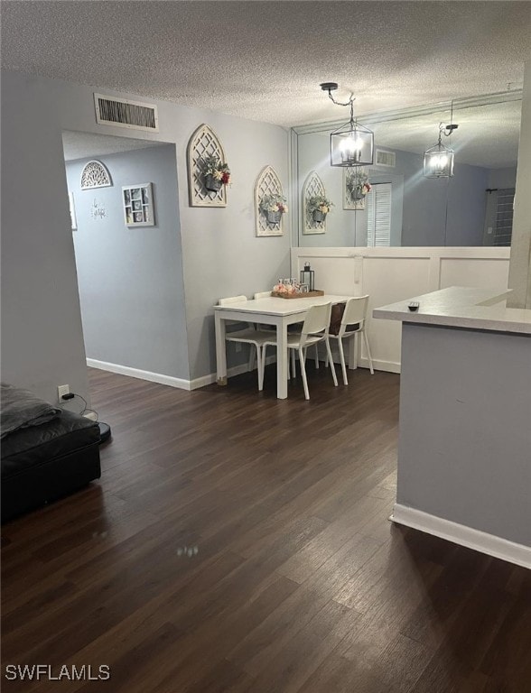 dining area featuring a textured ceiling and dark hardwood / wood-style floors