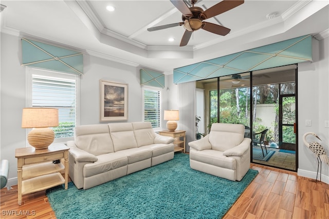 living room featuring wood-type flooring, crown molding, ceiling fan, and plenty of natural light