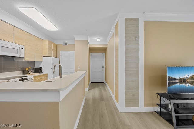 kitchen featuring light wood-type flooring, white appliances, kitchen peninsula, and crown molding