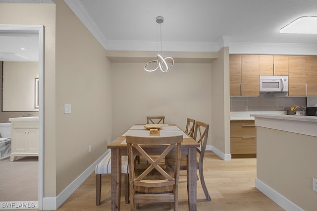 dining space featuring crown molding and light hardwood / wood-style floors