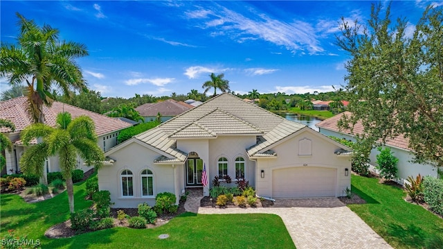 mediterranean / spanish house featuring a garage and a front lawn