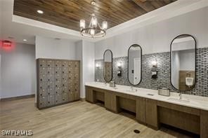 bathroom with a tray ceiling, hardwood / wood-style flooring, backsplash, wooden ceiling, and vanity