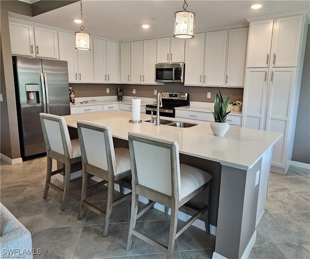 kitchen featuring pendant lighting, a kitchen island with sink, and stainless steel appliances