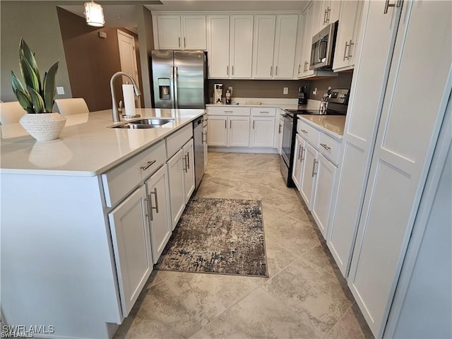 kitchen with sink, decorative light fixtures, a kitchen island with sink, white cabinetry, and stainless steel appliances