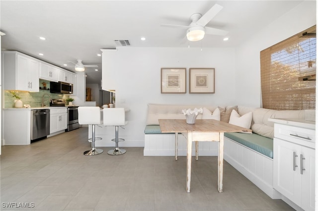 dining area featuring ceiling fan, sink, and breakfast area