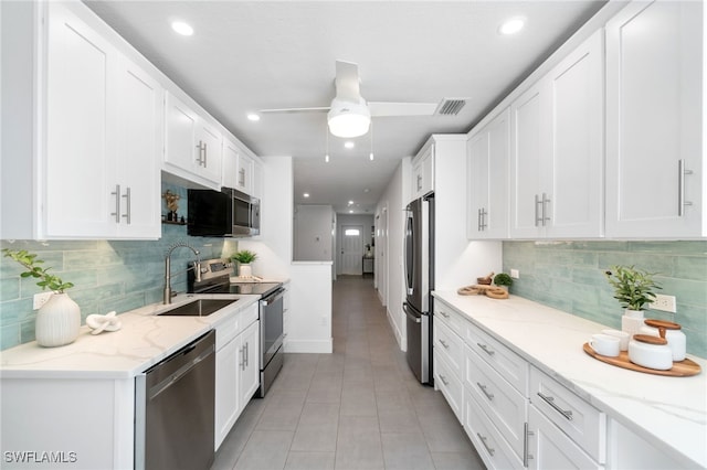 kitchen featuring ceiling fan, light stone countertops, appliances with stainless steel finishes, and sink