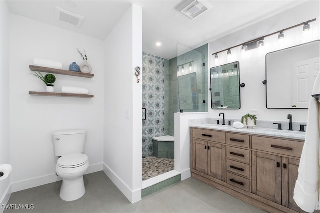 bathroom featuring vanity, a shower with shower door, and toilet