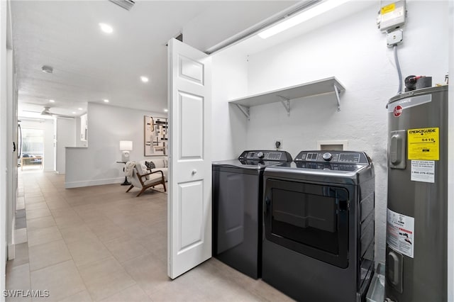 laundry area featuring light tile patterned floors, electric water heater, and independent washer and dryer