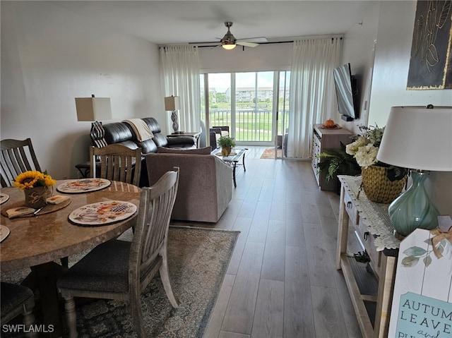 dining space with wood-type flooring and ceiling fan