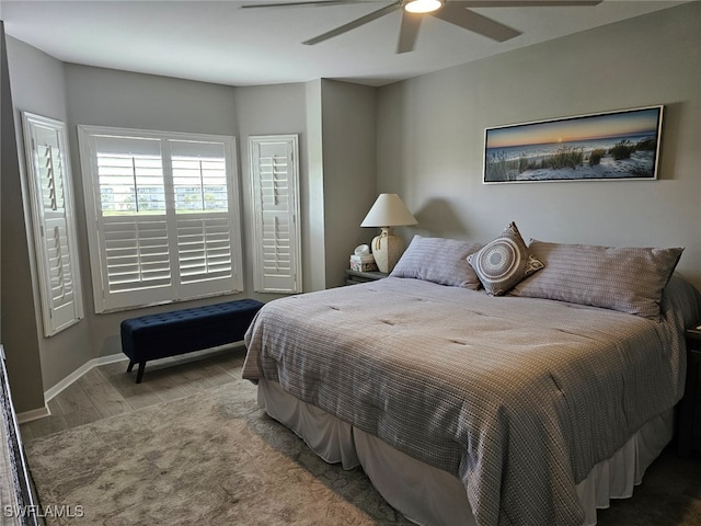 bedroom with ceiling fan, baseboards, and wood finished floors