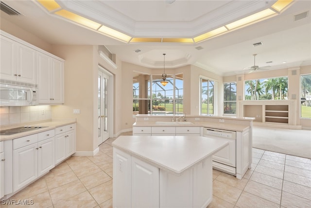 kitchen with ceiling fan, white cabinets, hanging light fixtures, white appliances, and a center island