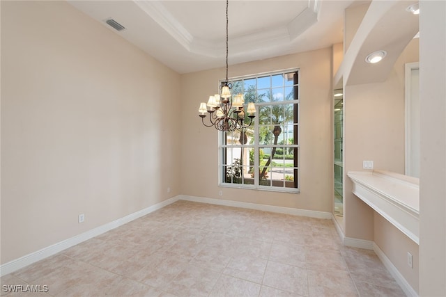 empty room with a notable chandelier, a tray ceiling, plenty of natural light, and ornamental molding