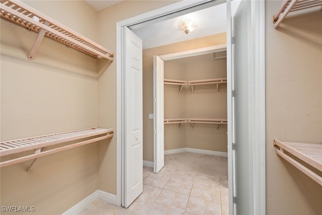 walk in closet with light tile patterned floors