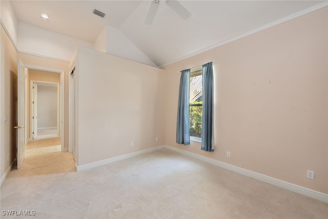 empty room with ceiling fan, light colored carpet, and lofted ceiling