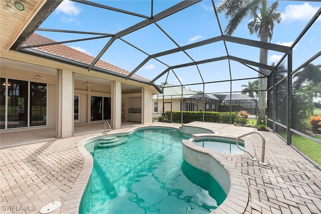 view of pool featuring a patio, glass enclosure, ceiling fan, and an in ground hot tub