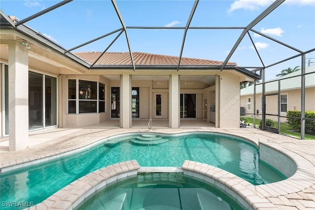 view of swimming pool with an in ground hot tub, glass enclosure, and a patio area