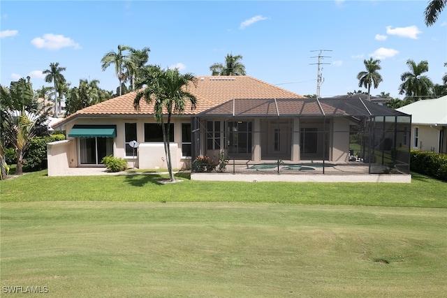 rear view of house featuring a patio, a yard, and a lanai