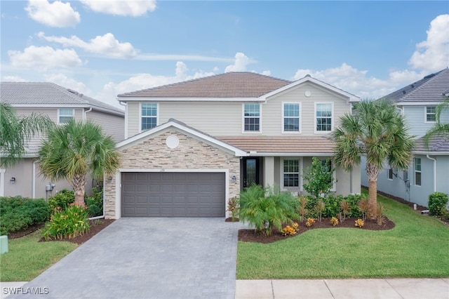 view of property featuring a garage and a front lawn