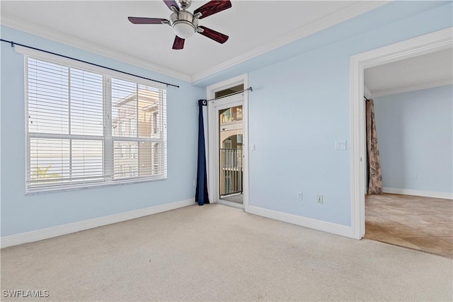 carpeted spare room featuring plenty of natural light, ceiling fan, and ornamental molding