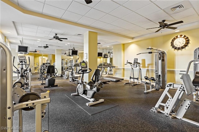 gym with a paneled ceiling and ceiling fan