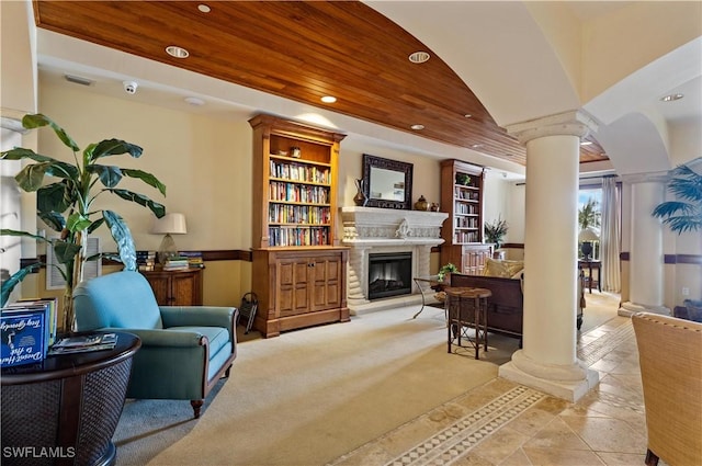 living area with ornate columns, built in shelves, and wooden ceiling