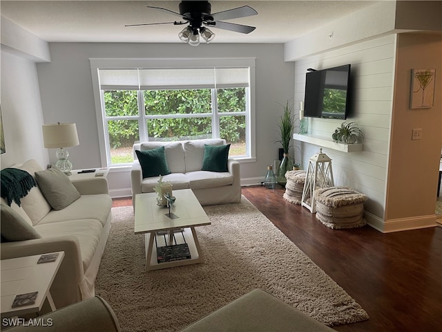 living room with dark wood-type flooring and ceiling fan