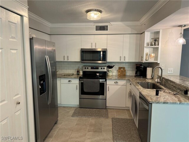 kitchen featuring white cabinetry, appliances with stainless steel finishes, decorative light fixtures, and sink