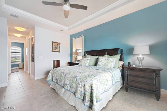 tiled bedroom featuring crown molding, a tray ceiling, and ceiling fan