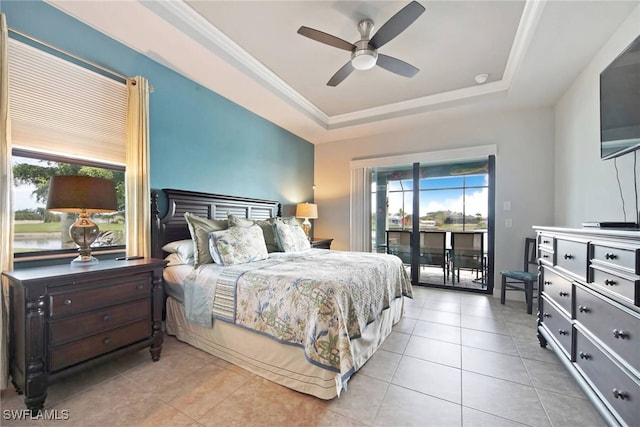 tiled bedroom with multiple windows, access to outside, a tray ceiling, and ceiling fan